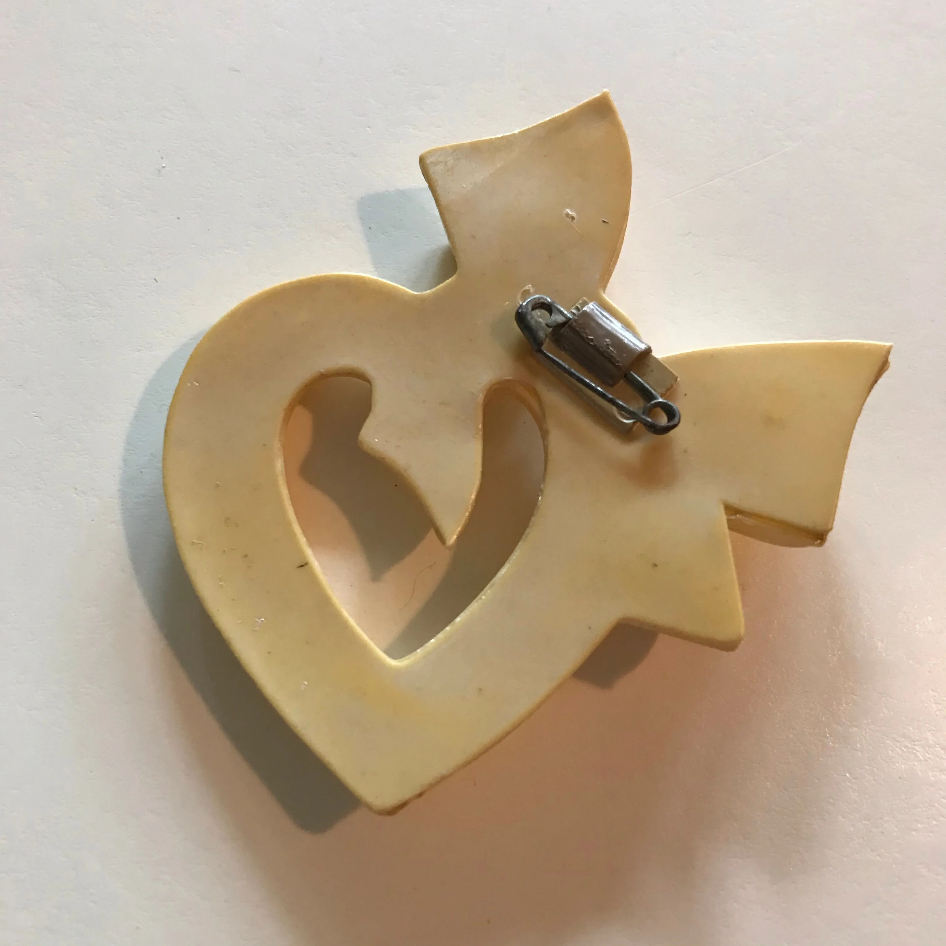 Ivory Celluloid Cartoon Heart and Bow Brooch circa 1930s